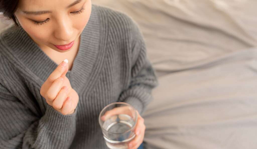 薬を飲む女性